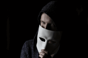 picture of a masked person exposing a part of their face.